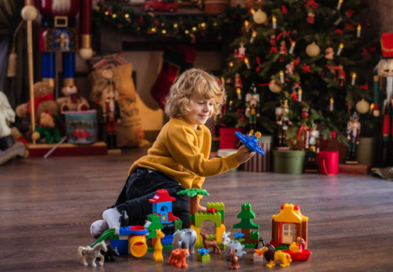 bambino gioca con le lego davanti albero di natale